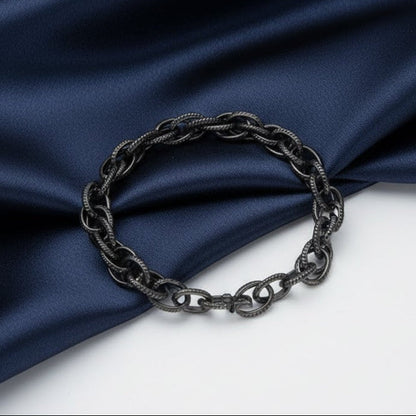 Black chain bracelet on a blue fabric background